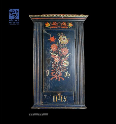 Polychromovaná rohová stříňka